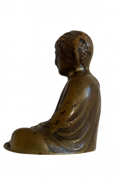 Left-facing profile of Japanese solid bronze Buddha showing wear on the head and shoulder