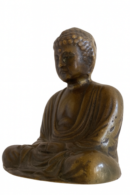 Three-quarter view of Japanese solid bronze Buddha showing robe folds and naturally worn surface