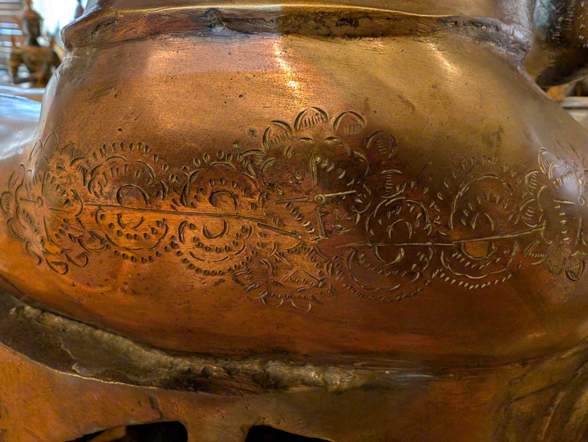 Close-up of engraved floral band across Green Tara's lower back