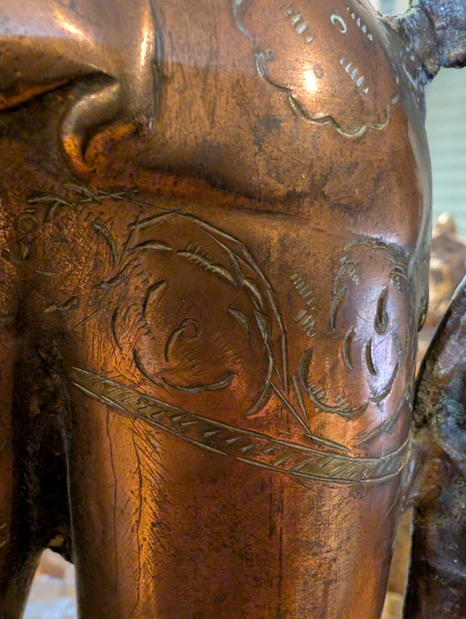 Close-up of engraved ritual and floral marks on Tara's upper arm