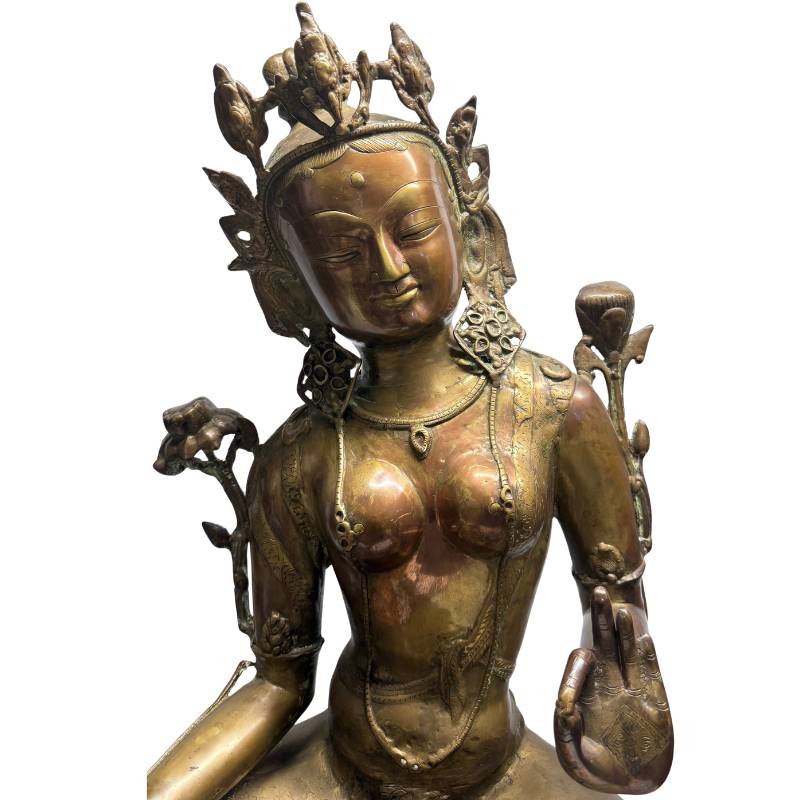 Close-up of Green Tara's face, jeweled crown and lotus flowers