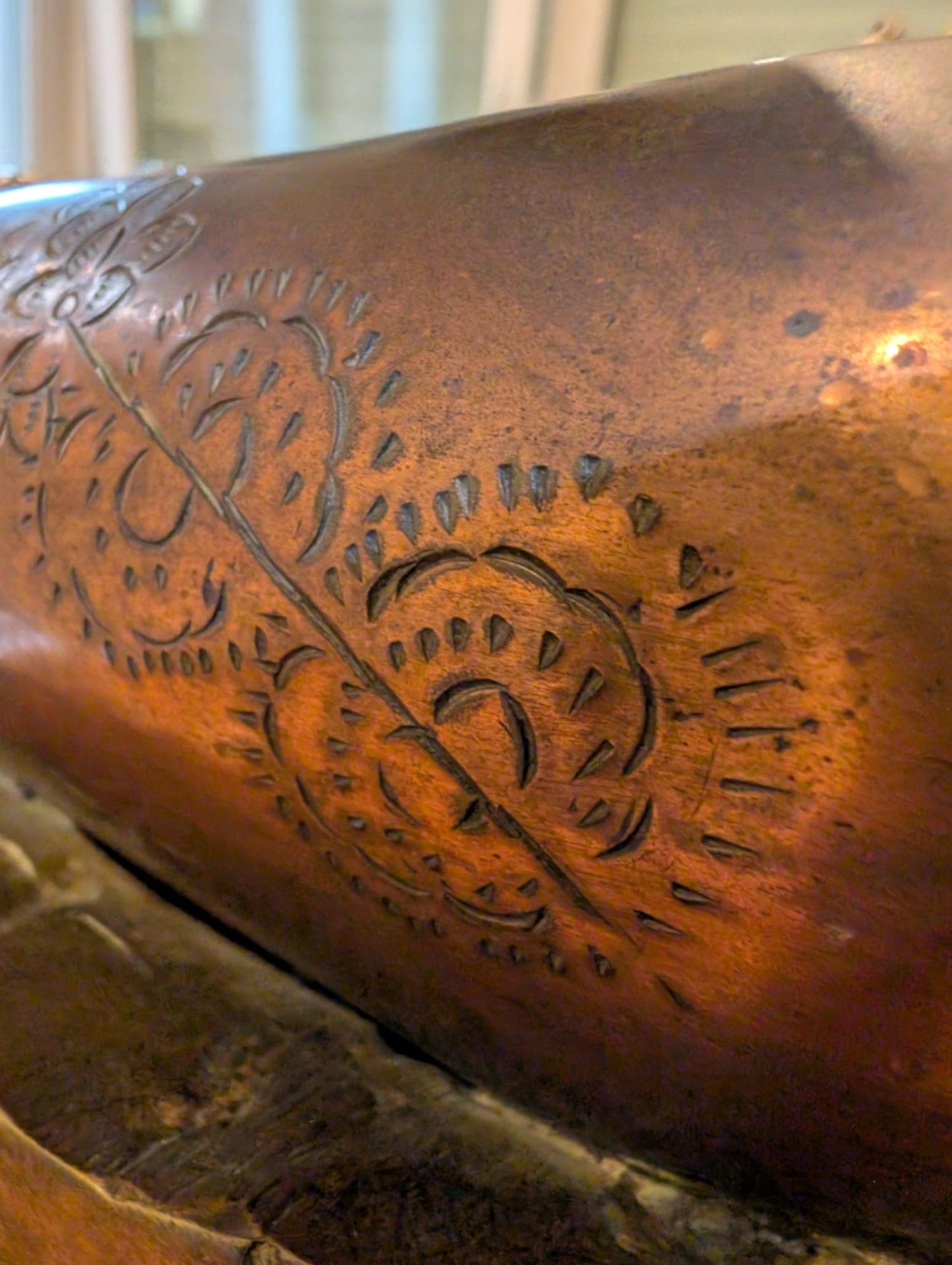 Close-up of circular ritual engraving on the bronze surface