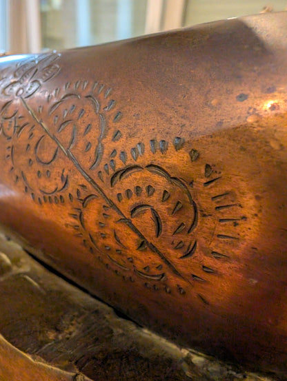 Close-up of circular ritual engraving on the bronze surface