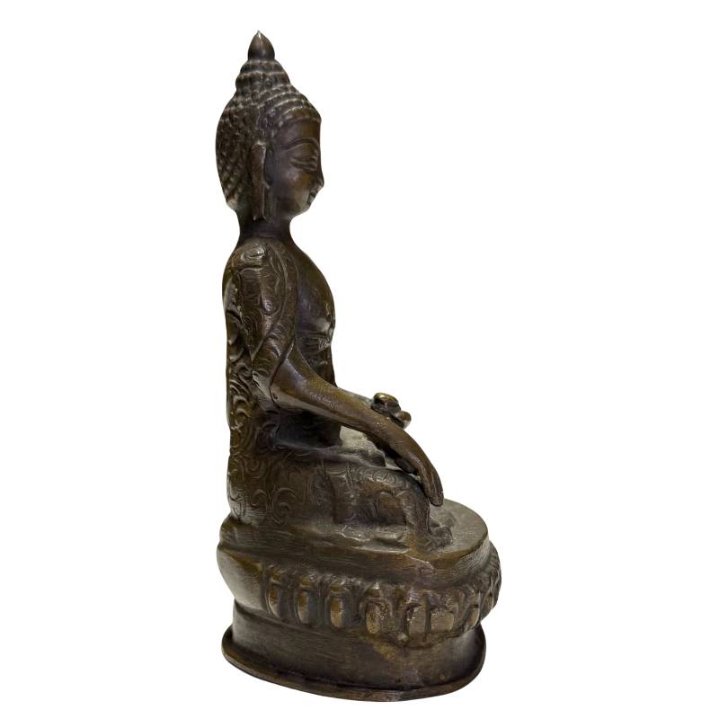 Zijaanzicht van de Boeddha met focus op de diepe, natuurlijke patina.