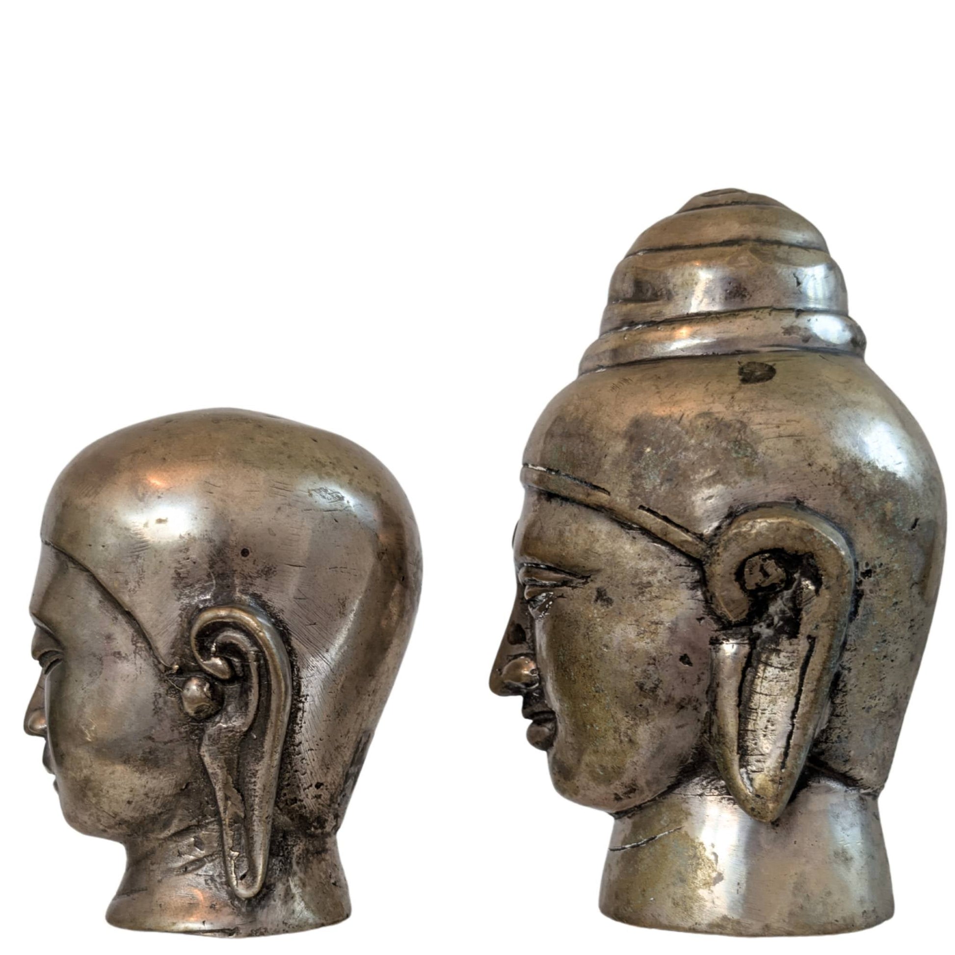 De achterzijde van beide bronzen beelden met focus op het goudbruine patina.