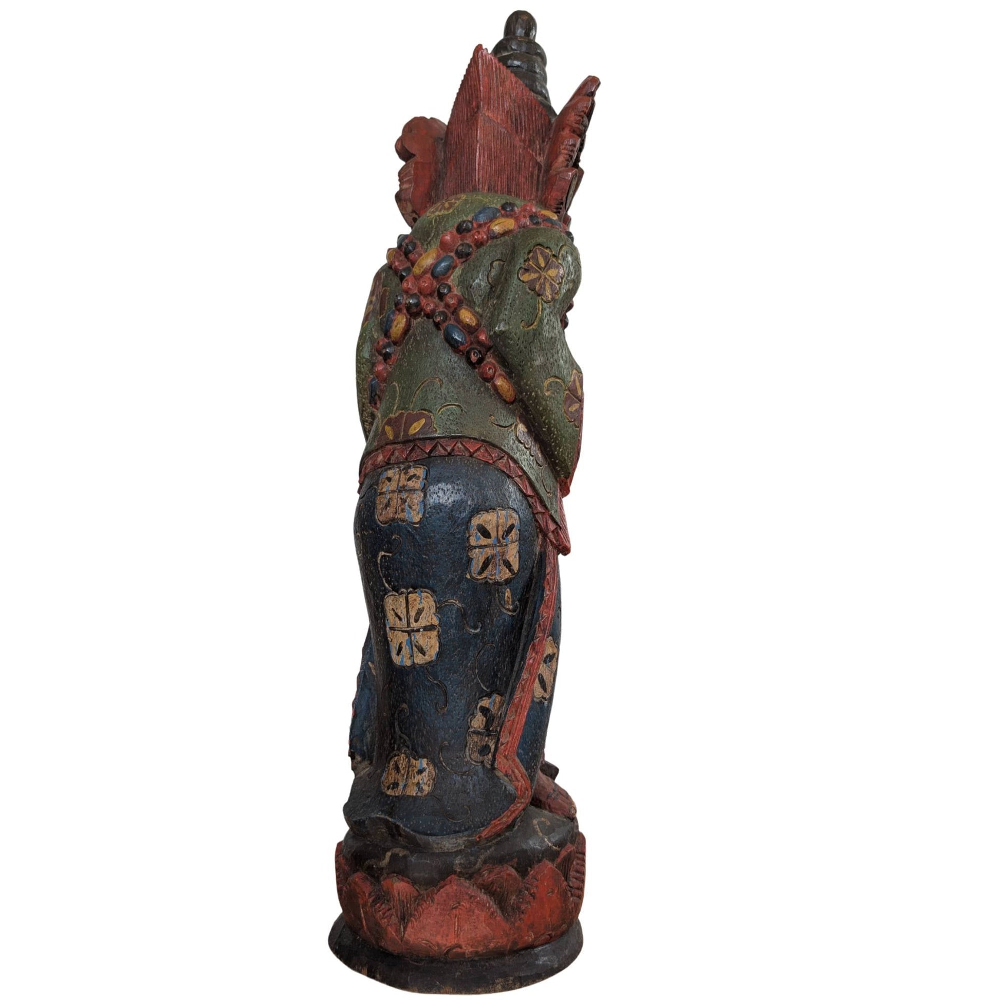 Achterzijde van het handgesneden Indonesische beeld met gedetailleerde kleding.