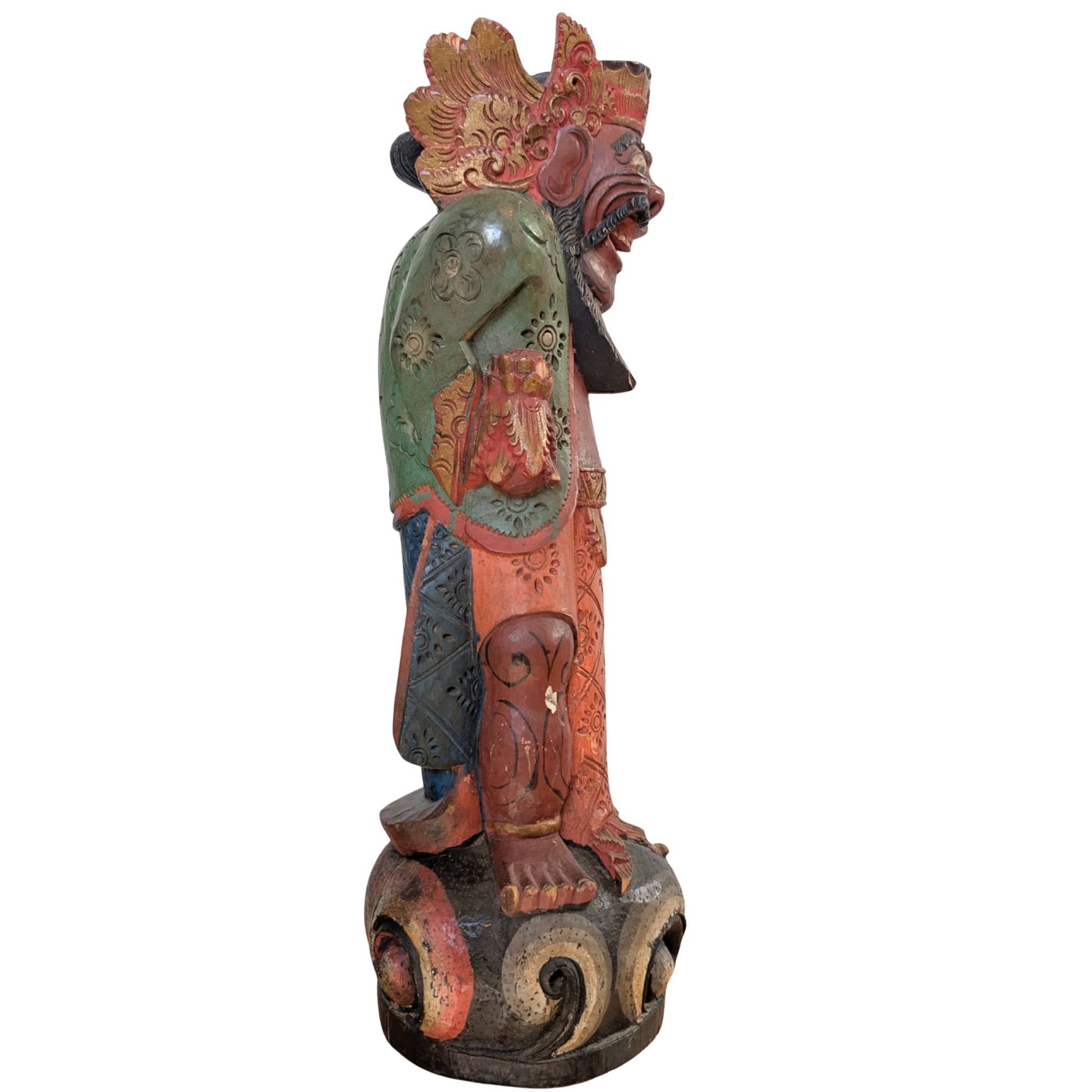 Zijaanzicht van het houten Balinese wachterfiguur op een gestileerde sokkel