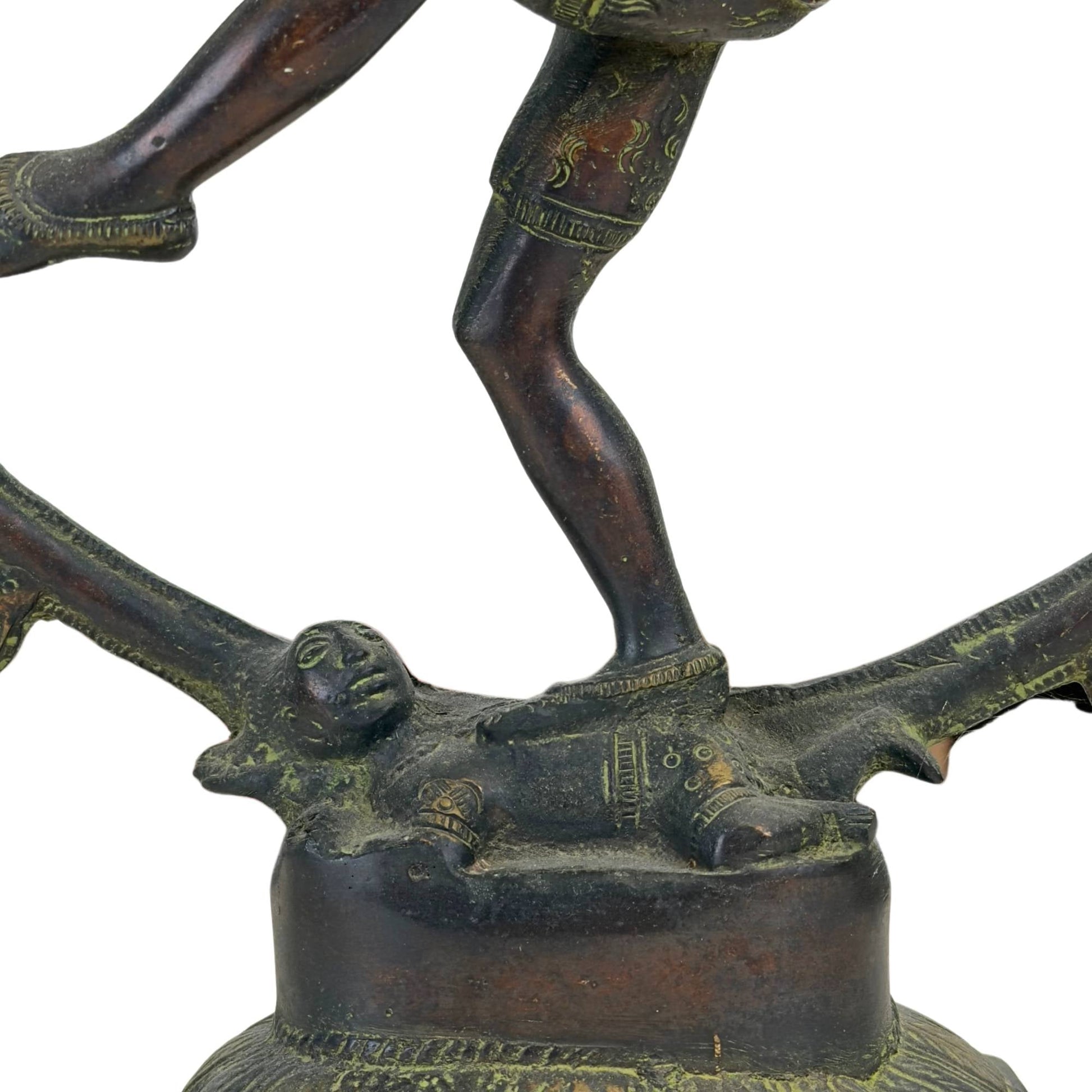 Detailopname van de dwerg Apasmara onder de voet van Shiva Nataraja op de bronzen lotusbasis