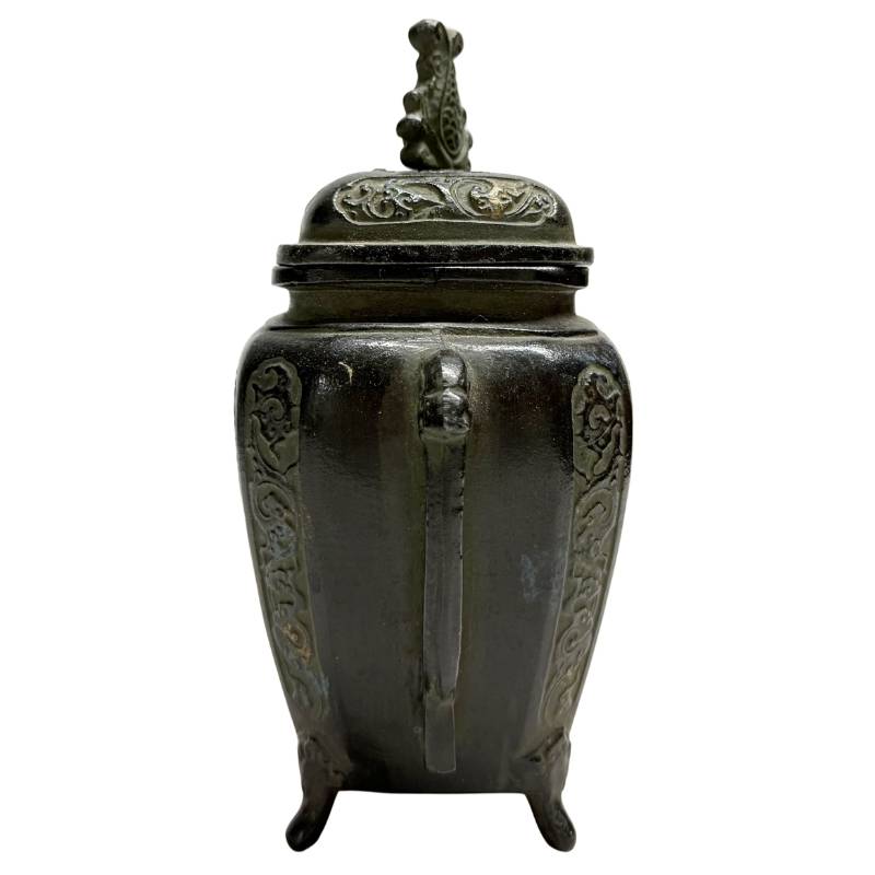 zijaanzicht van de Japanse bronzen brander, met de nadruk op het gegoten handvat en de diepe zwartbruine patina.