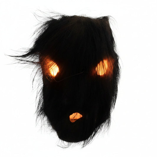Direct zicht op het rituele masker uit Nepal met de dichte beharing van organisch zwart yak-haar over de oogopeningen en de mondopening.