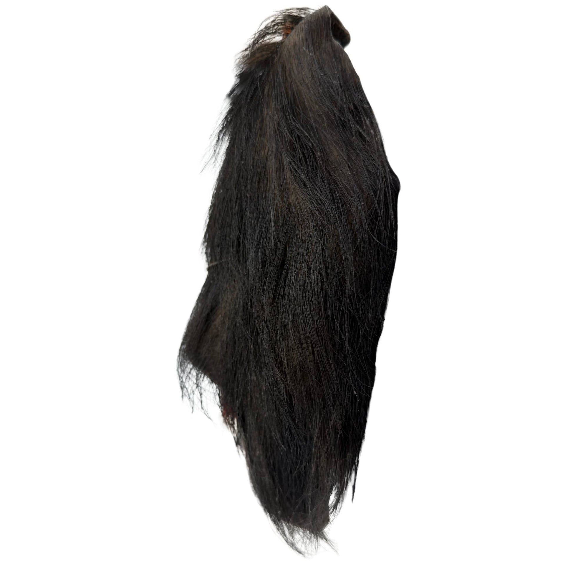 Zijaanzicht van het sjamanistische object, illustrerend de dikte van het gerookte yak-leder en de hangende lengte van de haarpartij.