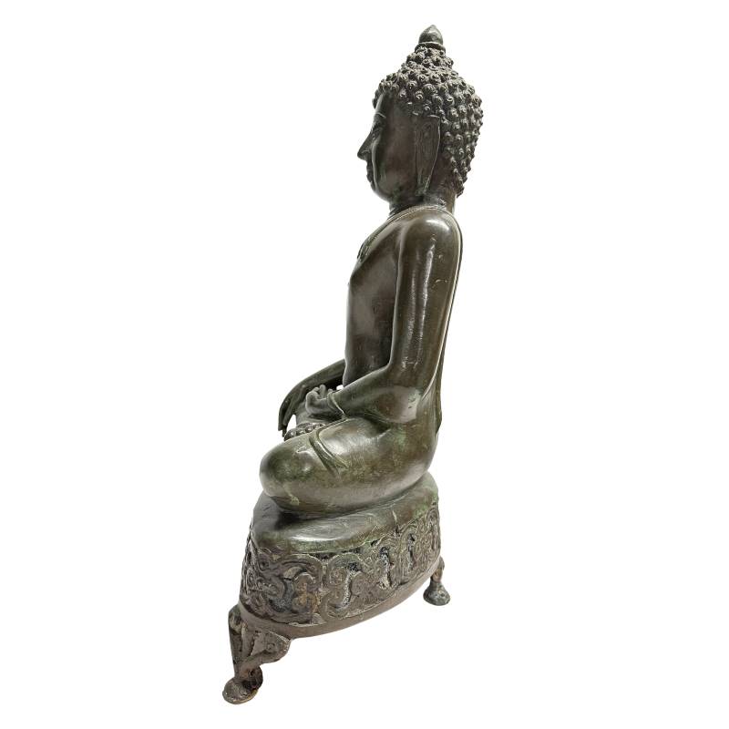 Volledig rechter zijaanzicht van de antieke bronzen Shakyamuni Boeddha, tonend de diepe olijfgroene patina en de stabiele drie-potige structuur van de altaartroon.