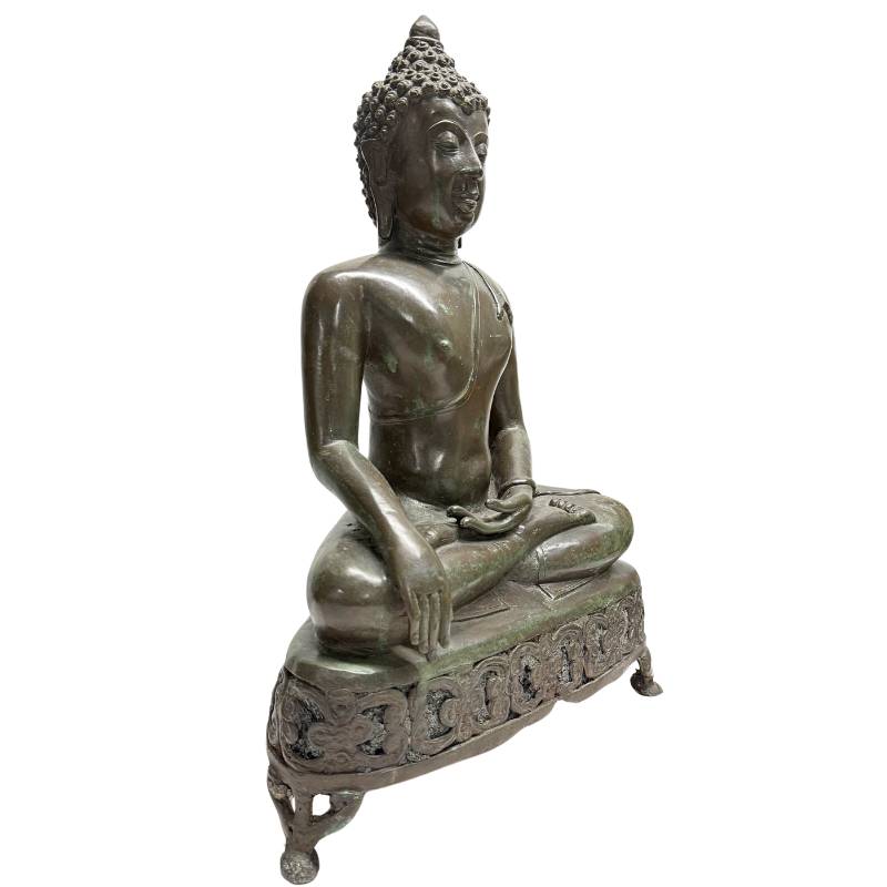 Schuin vooraanzicht van de rechterzijde van het 13,3 kg zware bronzen Boeddhabeeld, tonend het profiel van de opengewerkte basis met florale ranken.