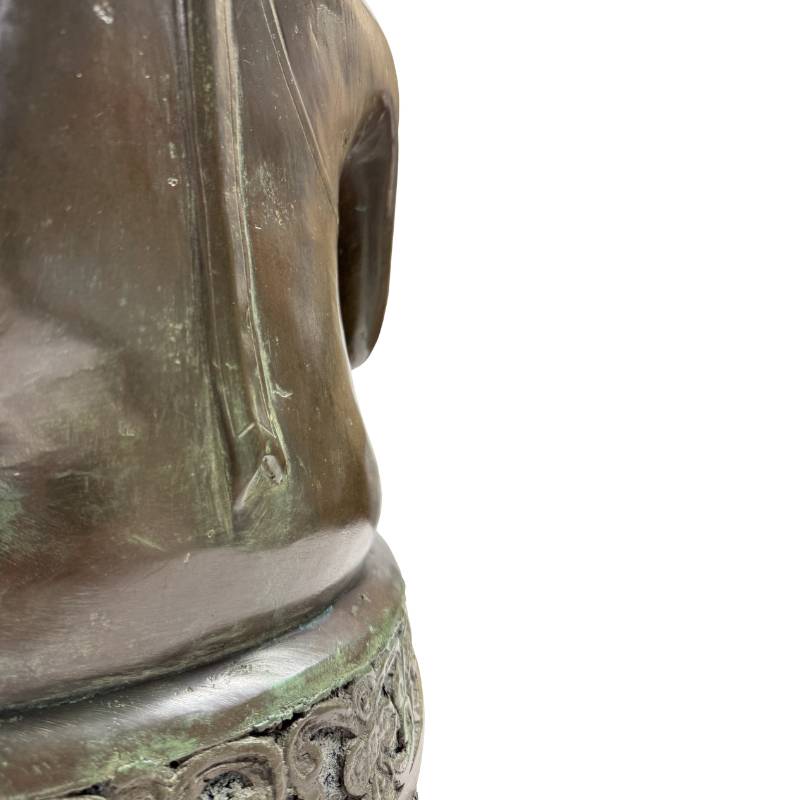 Close-up van de linkerflank van de torso en de overgang naar de troonbasis met natuurlijke goudbruine slijtage op de randen.