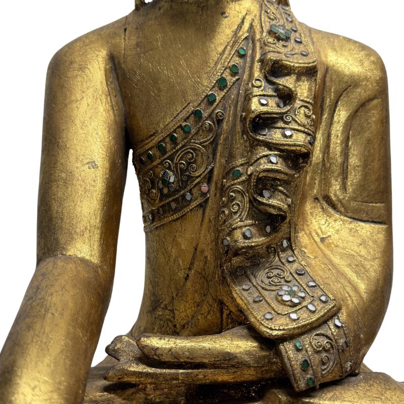 Close-up van de torso met de zwaar gelaagde plooien van het civara monnikskleed, opgebouwd uit gedetailleerd gedecoreerd Thayo lakreliëf en spiegelglas mozaïek.
