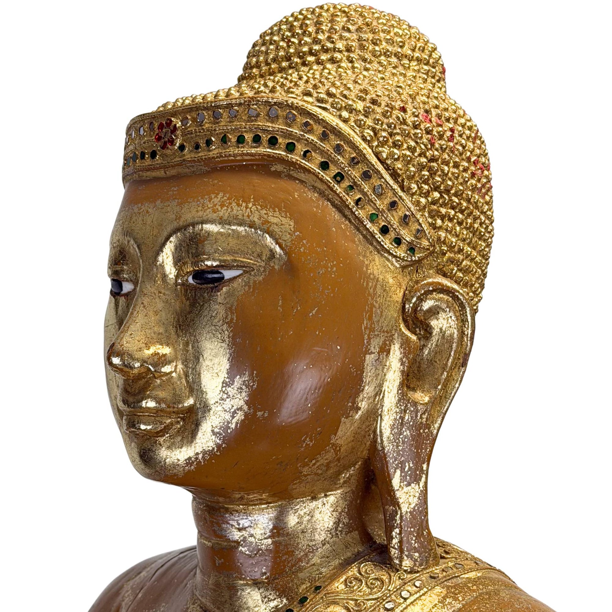 Gezicht van antieke Birmese Boeddha met ingelegde ogen, gouden haarband en rustige meditatieve uitstraling