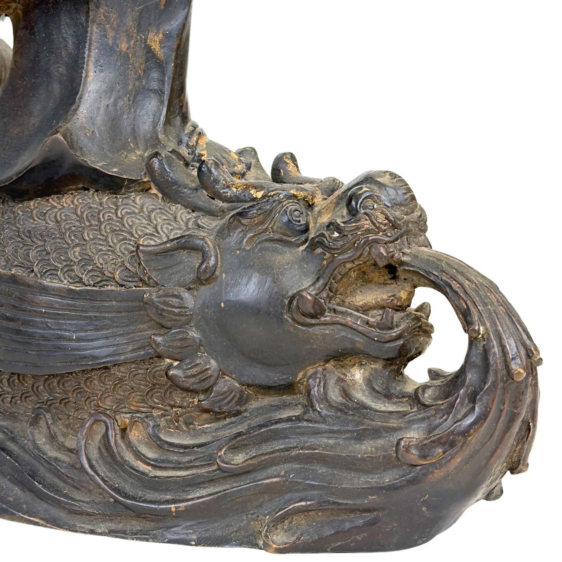 Antieke Guanyin op draakvis-waterbasis, uitgevoerd in brons met donkere patina en verguldingsresten