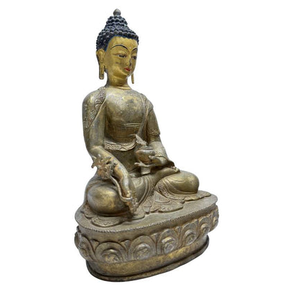 Three-quarter front view of Himalayan gilt bronze Medicine Buddha with healing attributes