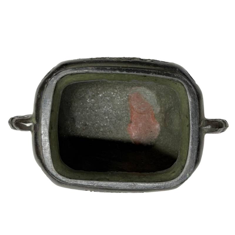Bovenaanzicht van de holle binnenzijde van het Japanse bronzen wierookvat met de authentieke gietsporen en een rode waszegelrest op de bodem.