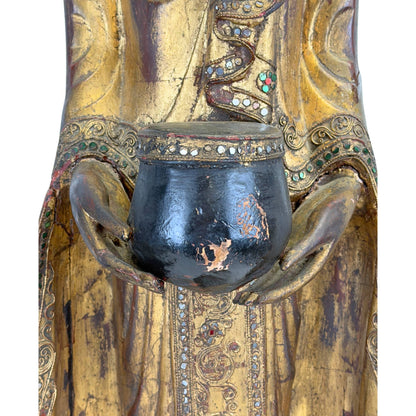 Black-lacquered alms bowl with aged surface on the antique Burmese Buddha