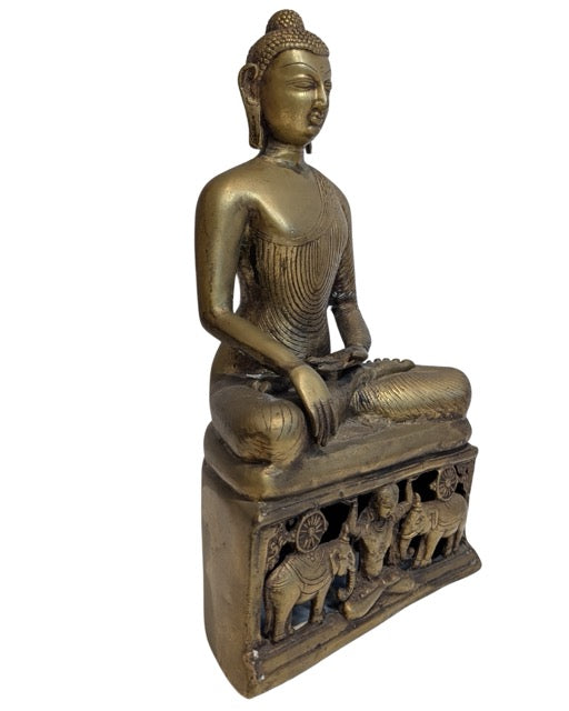 Decorated pedestal with elephants beneath the bronze Buddha