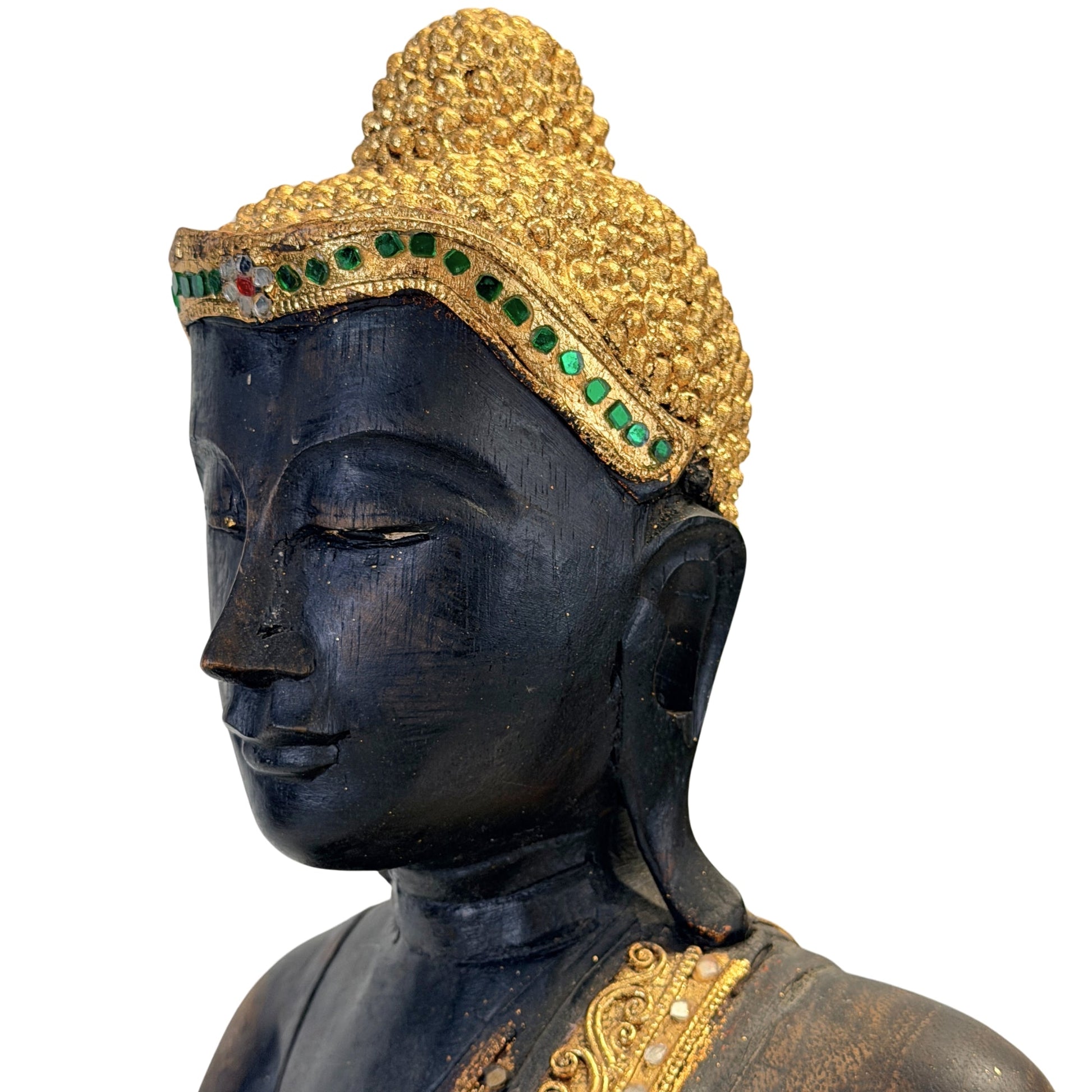 Close view of the Buddha's face with gilded hair curls and green glass inlay