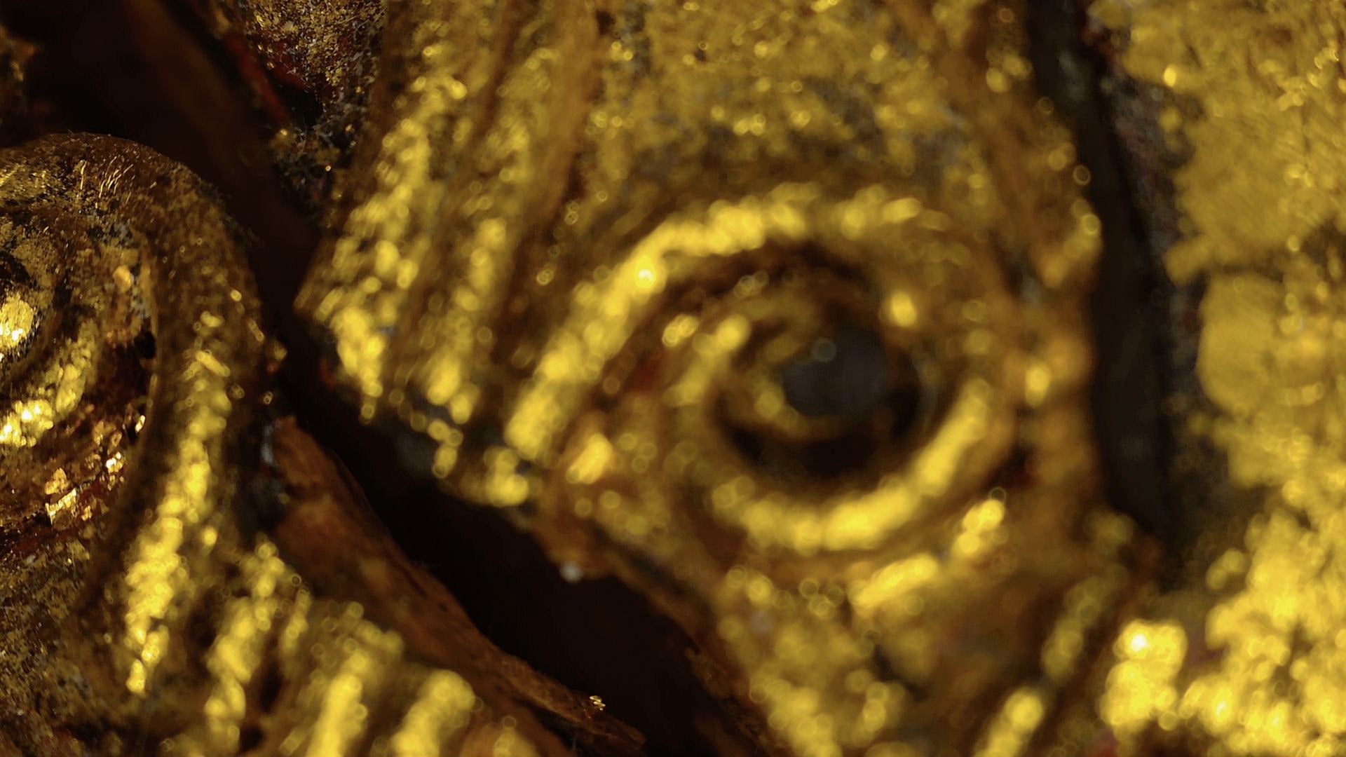 Microscopic detail of historic gilded relief on the Burmese Mandalay Buddha