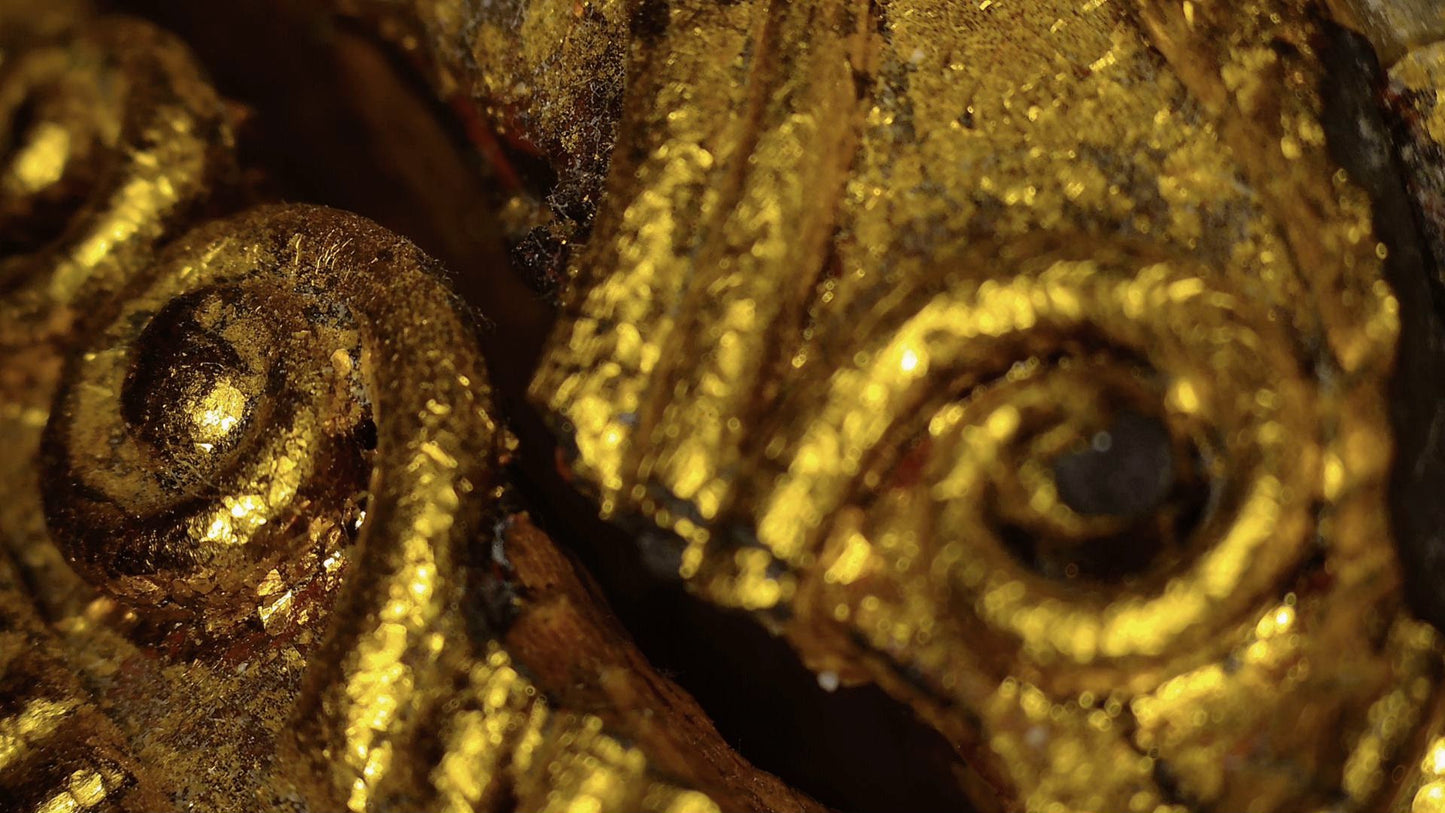 Microscopic detail of gilded spiral ornament on the Burmese Buddha's robe