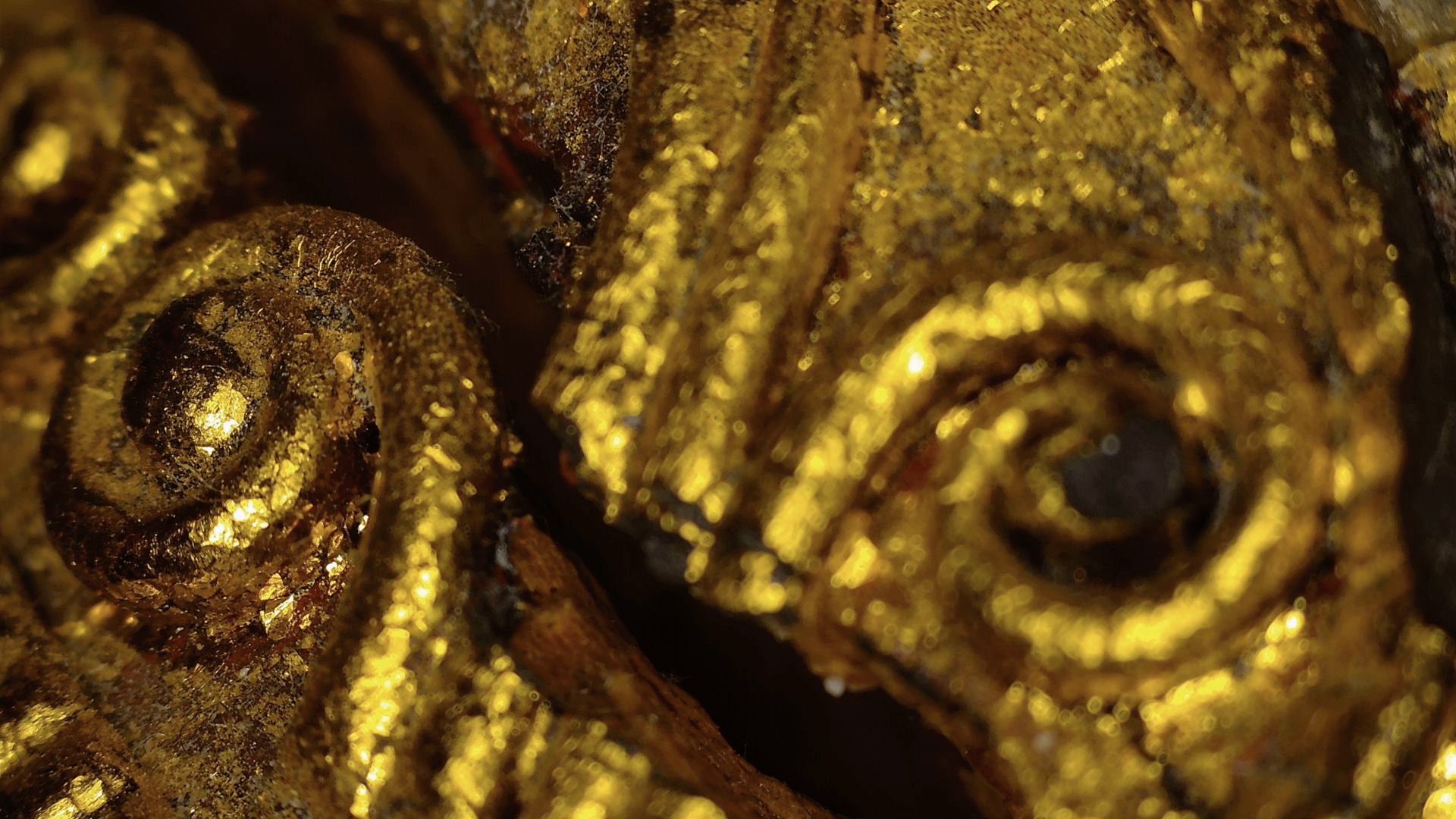 Microscopic detail of gilded spiral ornament on the Burmese Buddha's robe
