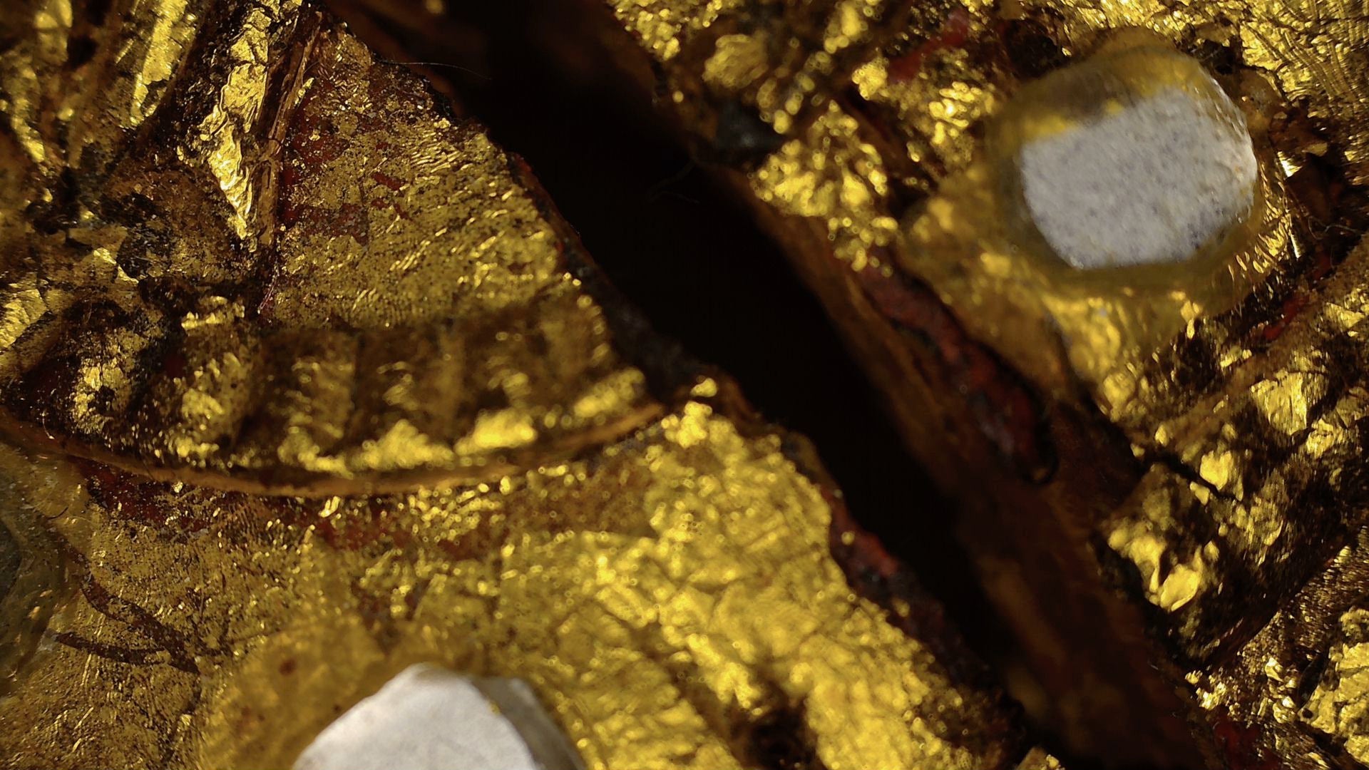 Microscopic detail of aged gilding and mirror-glass inlay on the Burmese Mandalay Buddha