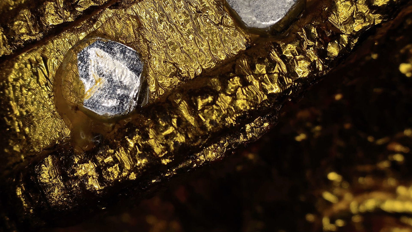 Microscopic view of mirror glass and layered historic gilding on the Mandalay Buddha