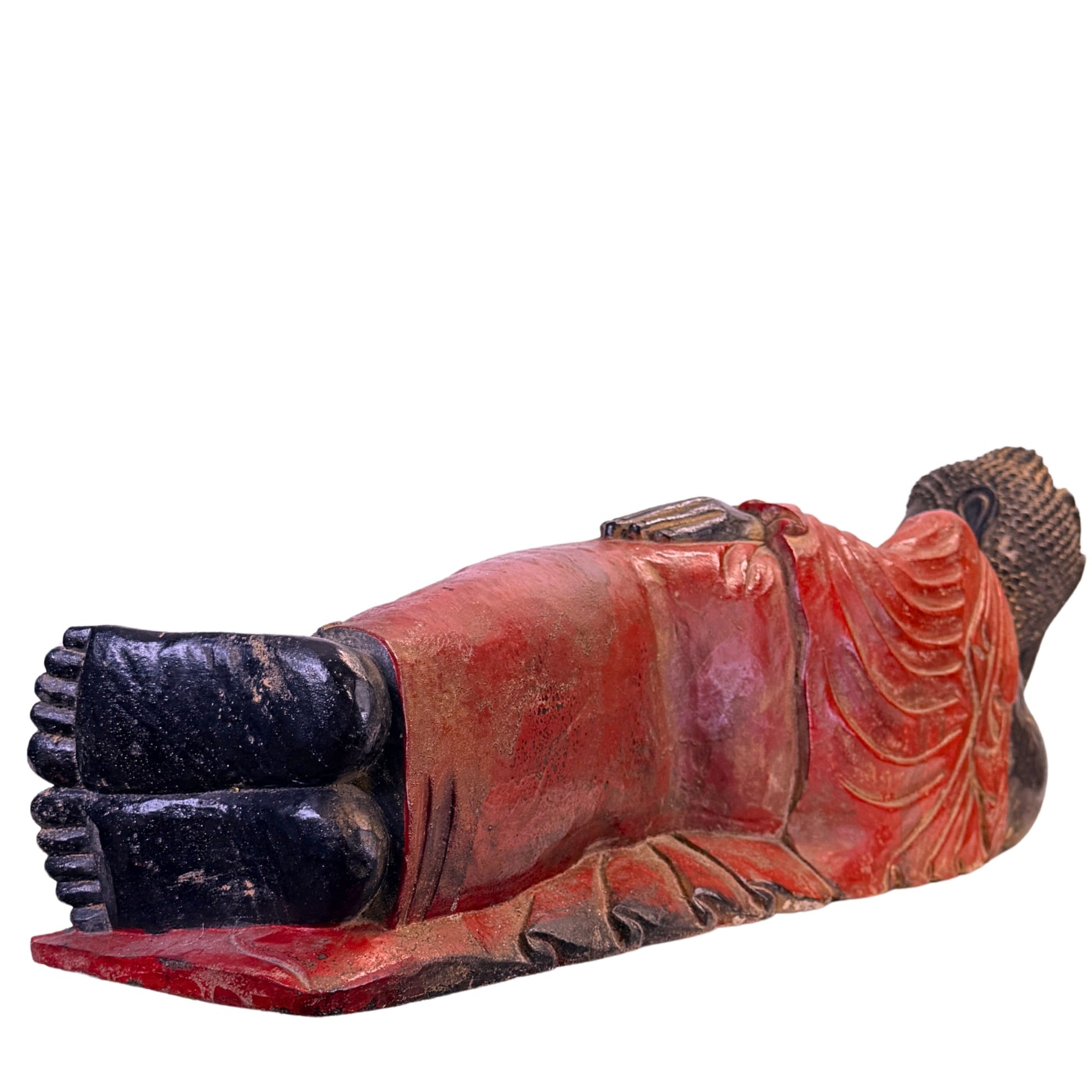 Low-angle view of the feet and red robe of the antique Burmese reclining Buddha