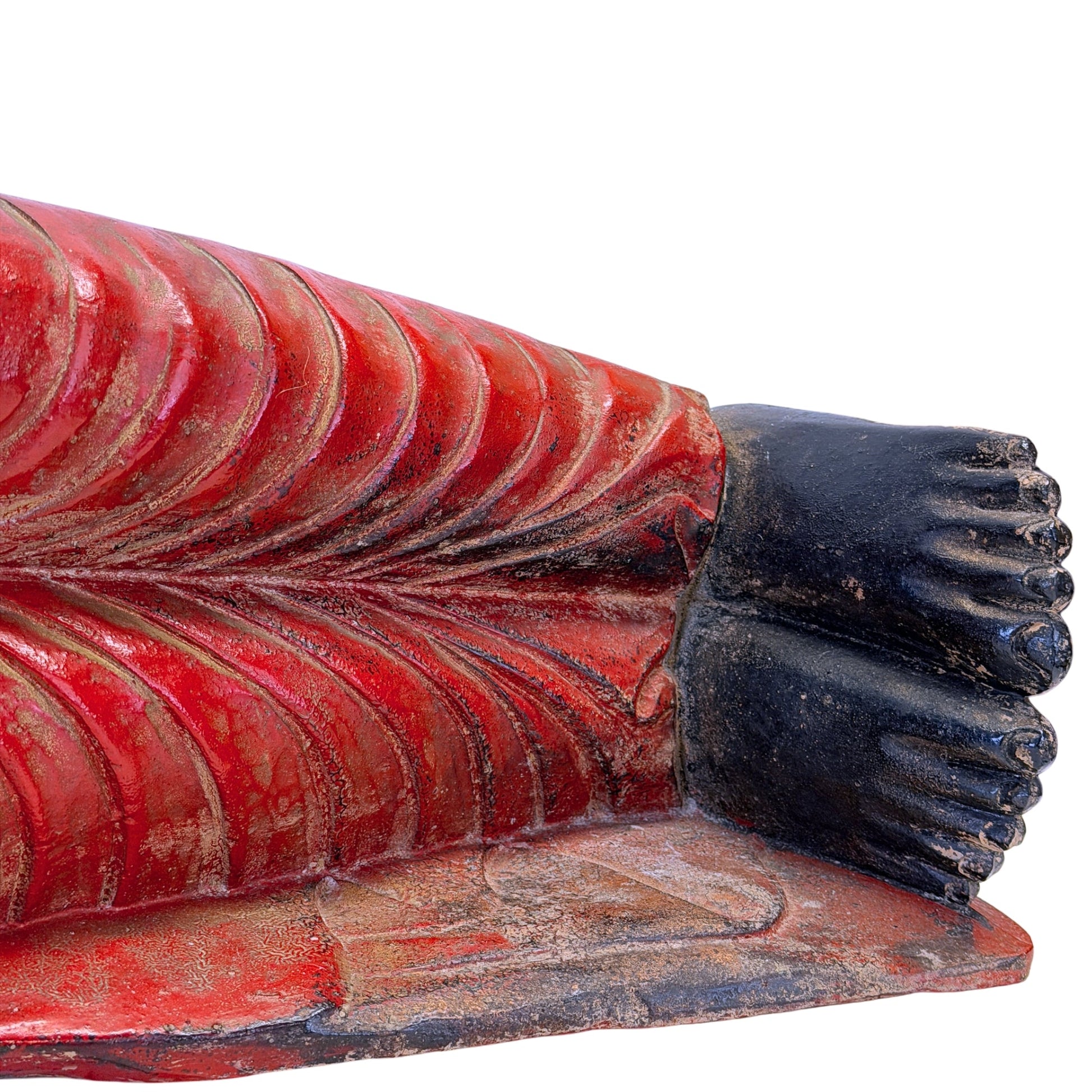 Feet and red polychrome robe of the antique Burmese reclining Buddha