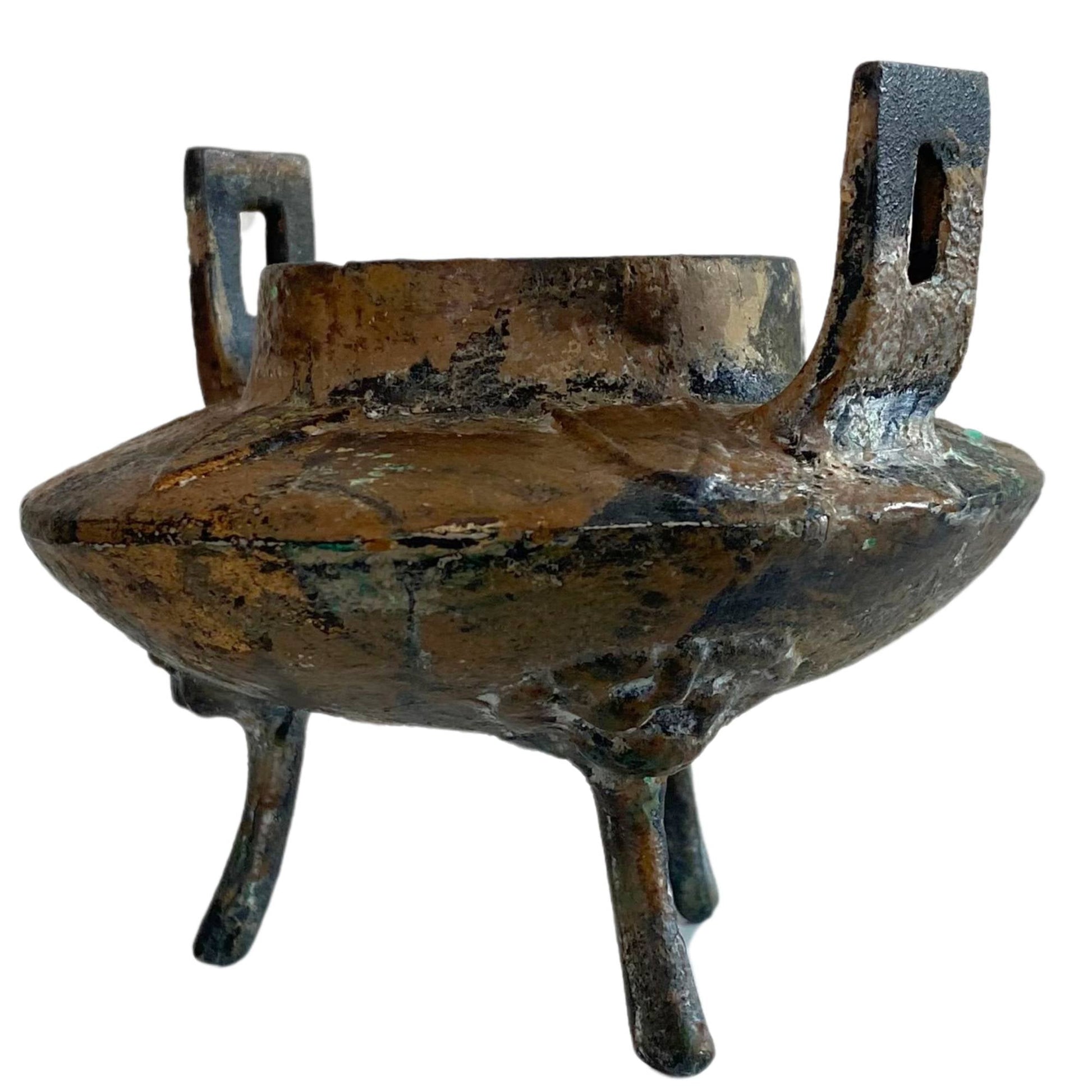 Detailopname van de gietijzeren tripod poten met archaïsche Taotie-maskers.