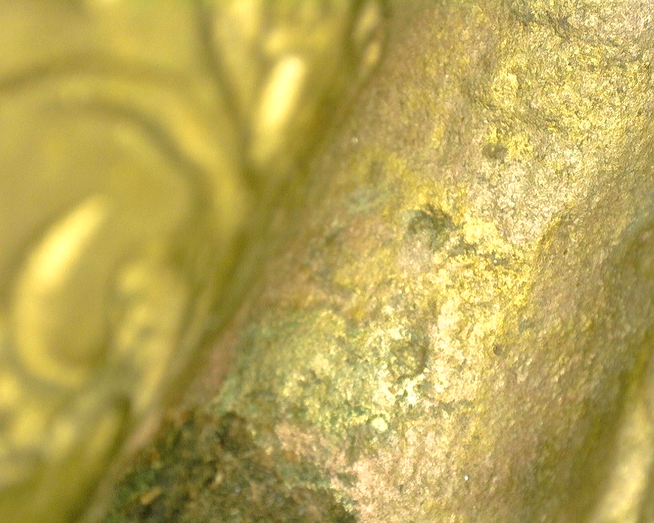 Close-up van het vuurvergulde bronzen oppervlak met natuurlijke oxidatie en gebruiksslijtage.