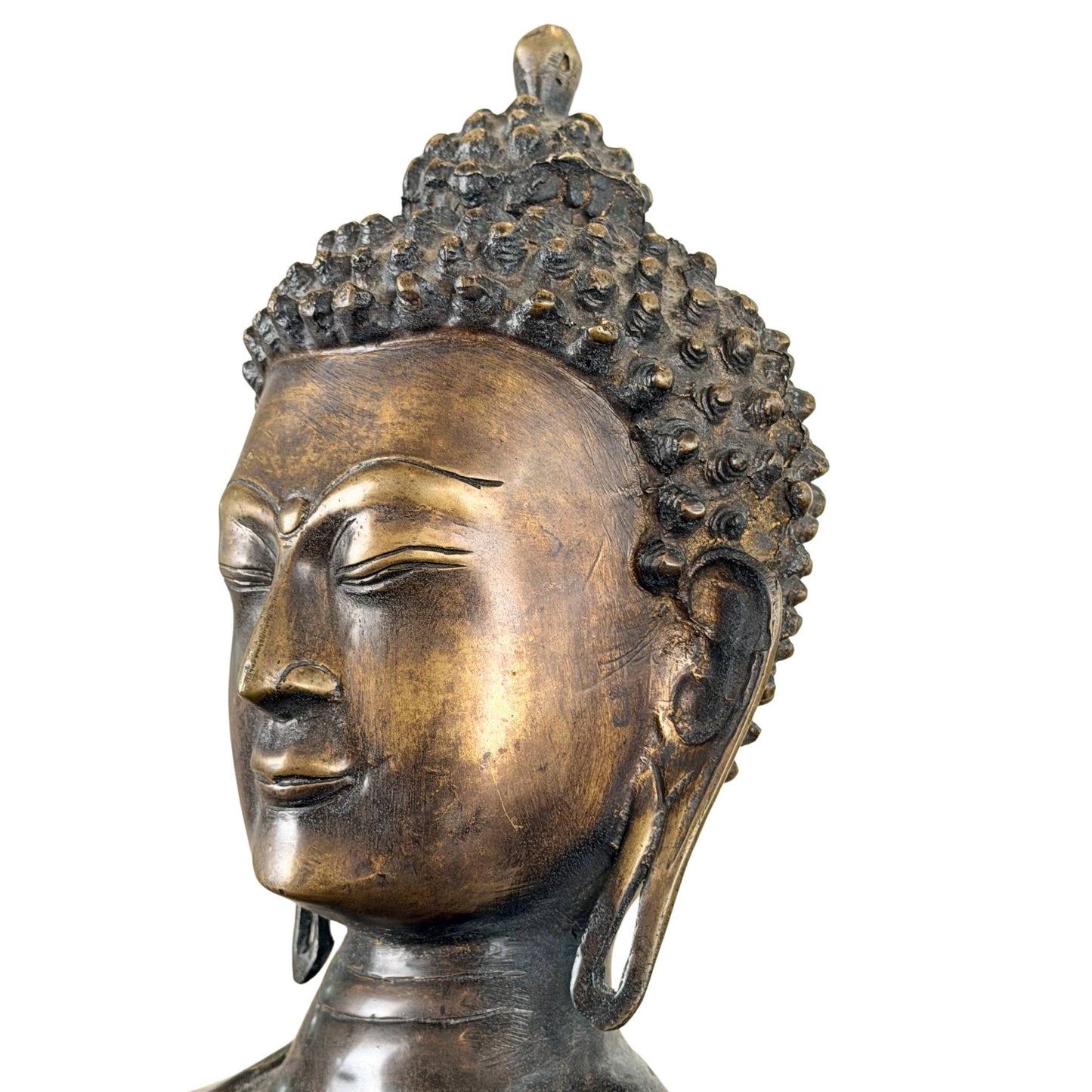 Serene gezichtsuitdrukking van een Himalaya Boeddha in vuurverguld brons met donkere patina en traditionele vormgeving
