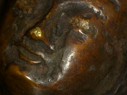 Close-up of facial wear and gilding traces on Himalayan bronze Buddha