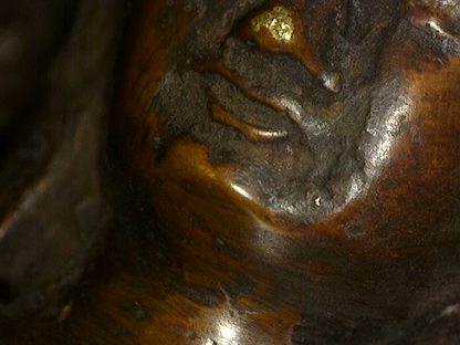 Close-up of face and remaining gilding on Himalayan bronze Buddha