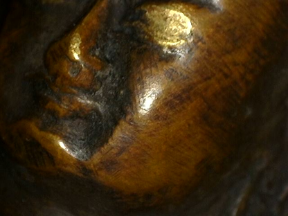 Close-up of gilded eye and facial patina on Himalayan bronze Buddha
