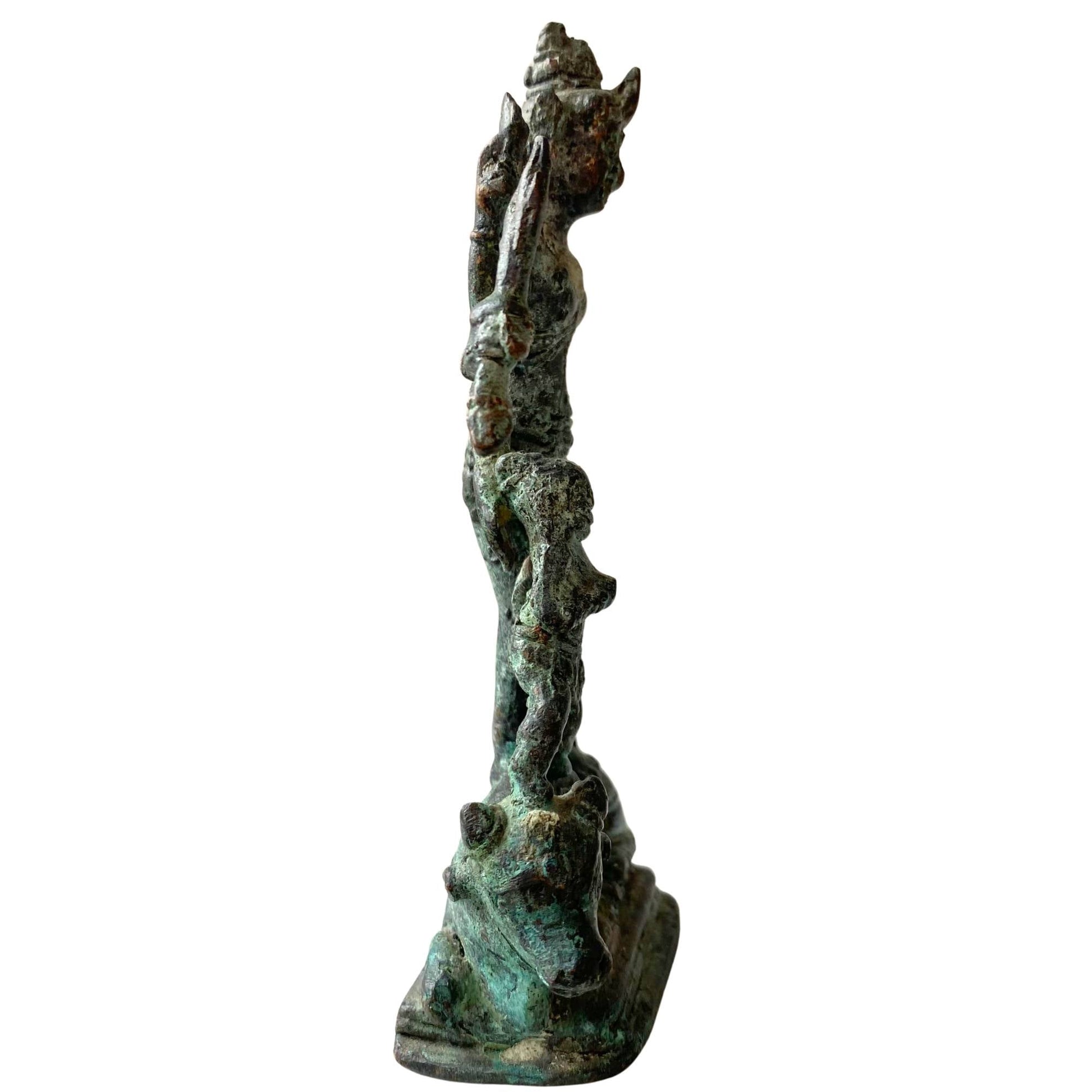 Zijaanzicht van de bronzen Durga met focus op de natuurlijke minerale afzettingen.