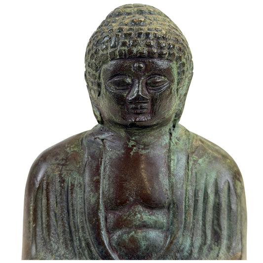 Close view of the Japanese bronze Buddha’s face, patterned hair and upper robe