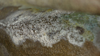 Macro view of the interior casting surface with pale mineral deposits and oxidation