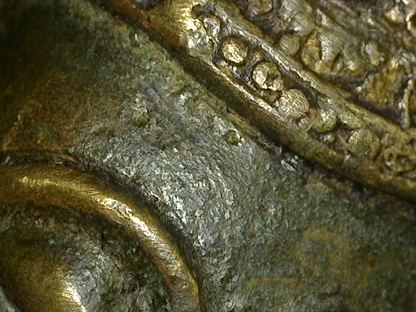Close view of the patina and worn gilt surface