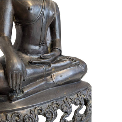 Close-up of the earth-touching hand, crossed legs and openwork pedestal of Burmese bronze Buddha