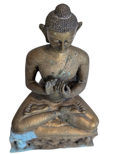 Carved protective figures on the ornate Buddha base