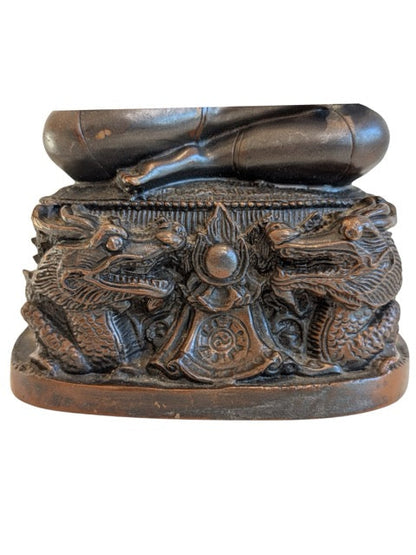 Thai bronze Buddha seated above a protective dragon base