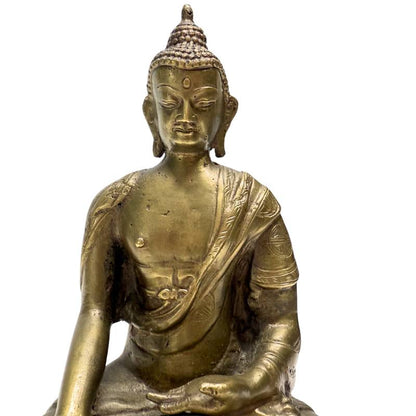 Close-up of the Chinese bronze Buddha's face, torso and robe