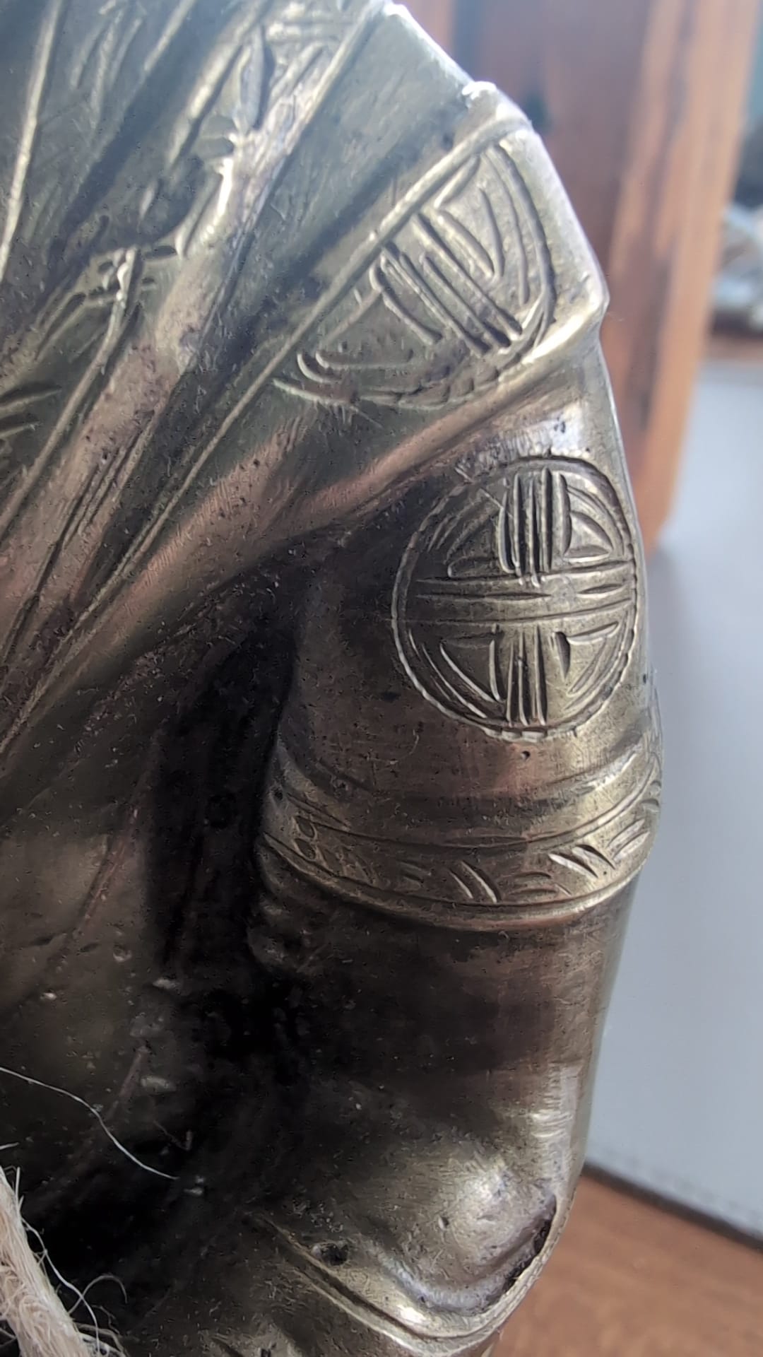 Close-up of engraved Shou longevity medallions on the robe sleeve