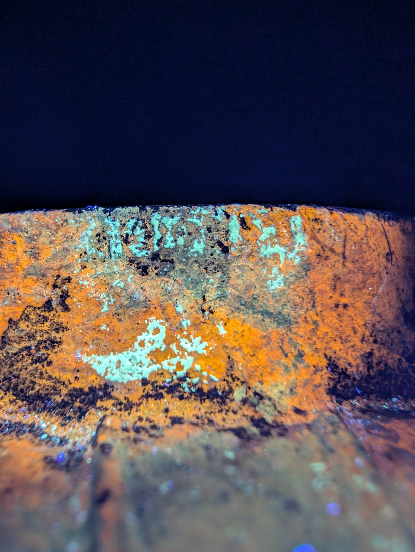 Macrofoto van de zwarte magnetiet-laag die kenmerkend is voor oud gietijzer.