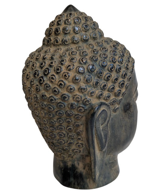 Side profile of the bronze Buddha head with aged patina